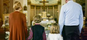crianças na missa com os pais